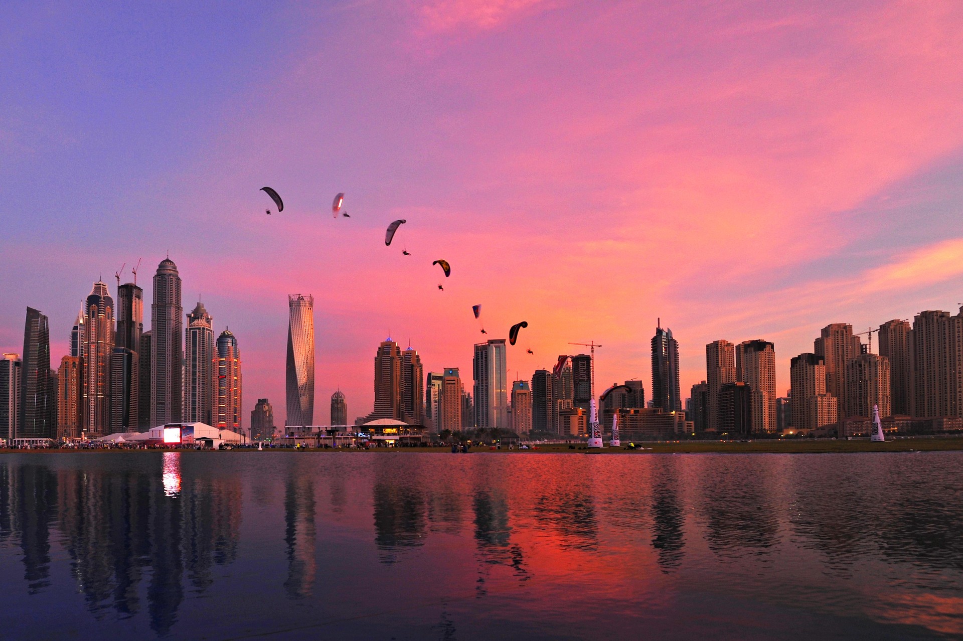 Modern Buildings By River Against Cloudy Sky During Sunset In City
